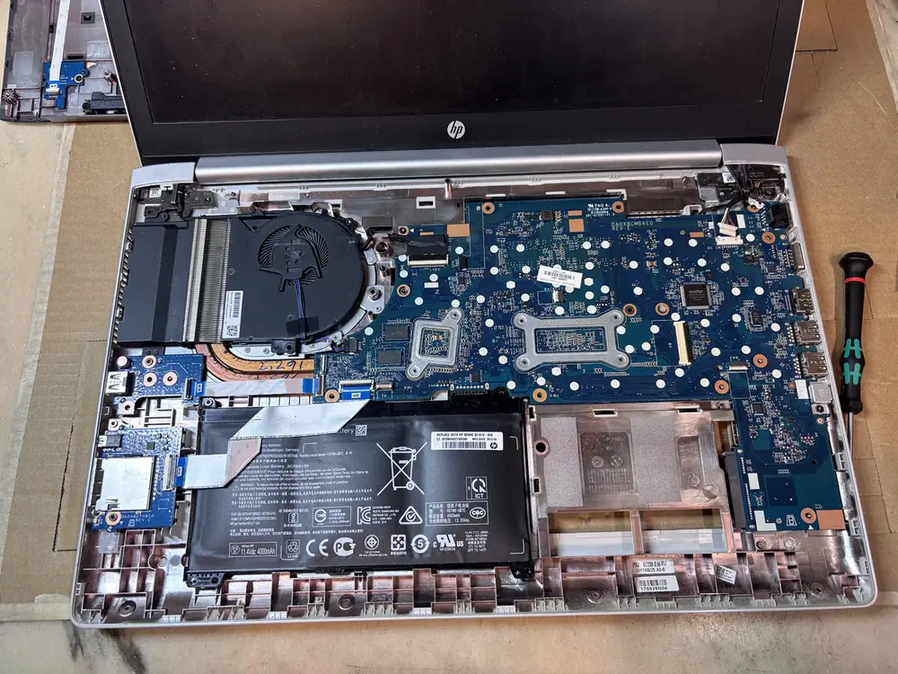 Laptop HP aperto: scheda madre, dissipatore e ventola durante la manutenzione termica